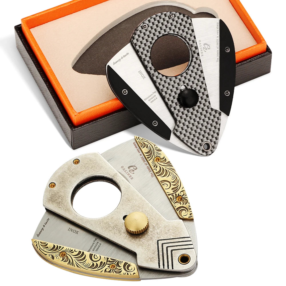 Two cigar cutters with decorative handles on a white background