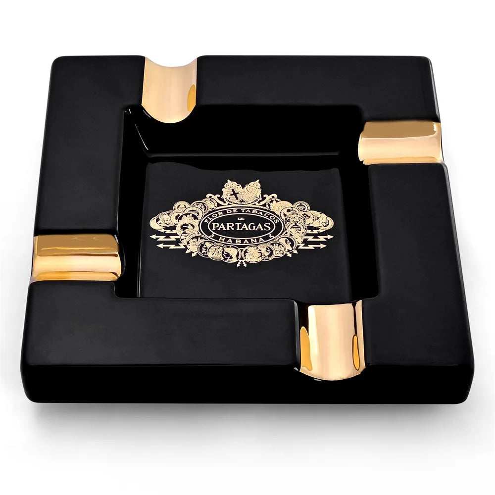 Black ashtray with gold accents featuring Partagas logo on a white background