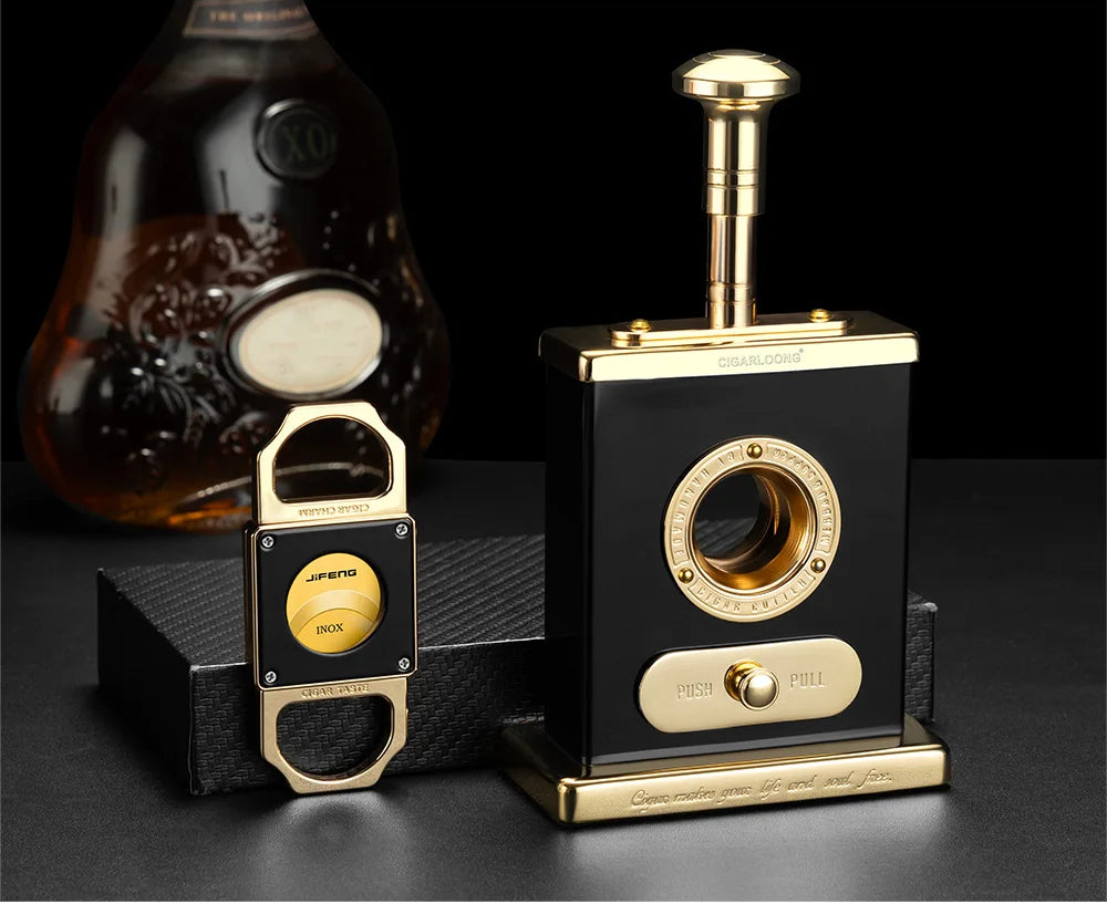 Black and gold desktop cigar cutter and guillotine cutter on a dark background.