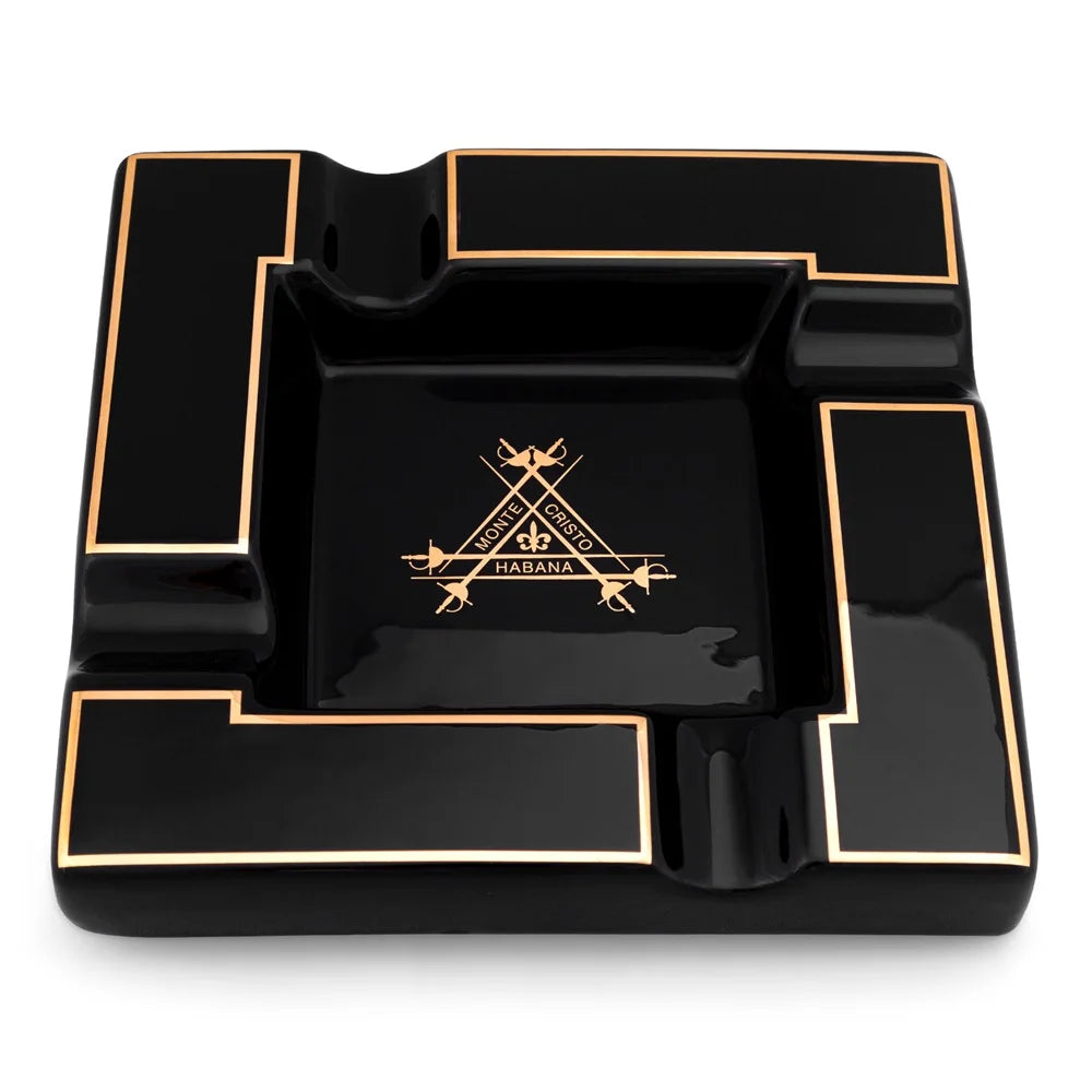 Black ashtray with gold accents and monte cristo logo on a white background