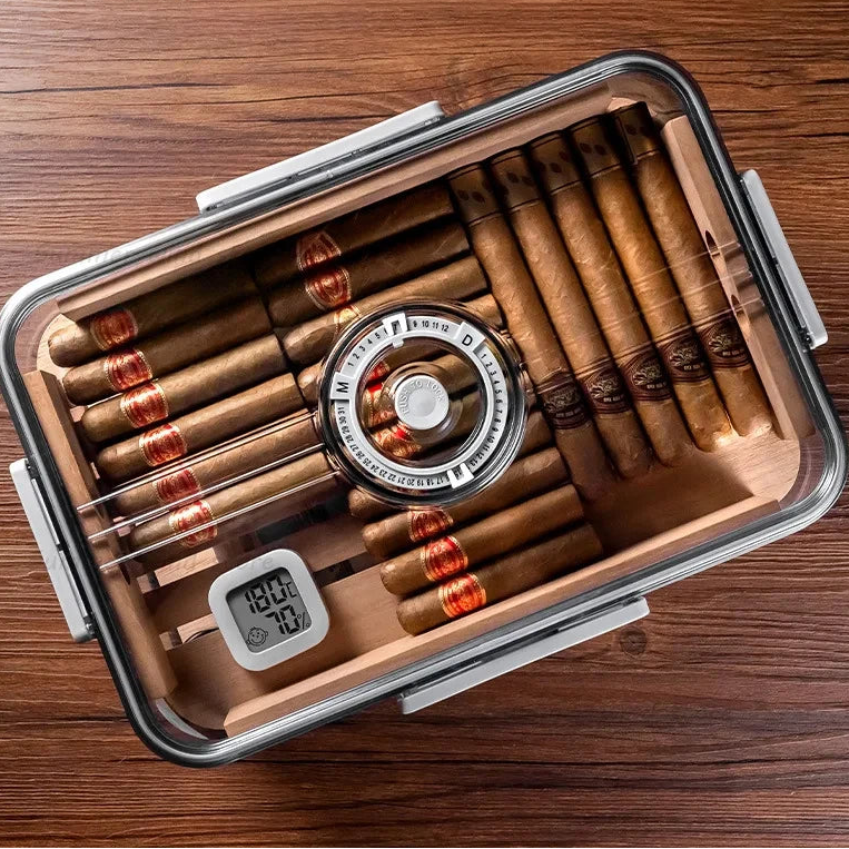 Cigar humidor with cigars and a digital thermometer on a wooden surface